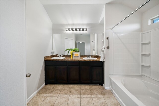 bathroom featuring tile patterned floors, vanity, lofted ceiling, and washtub / shower combination