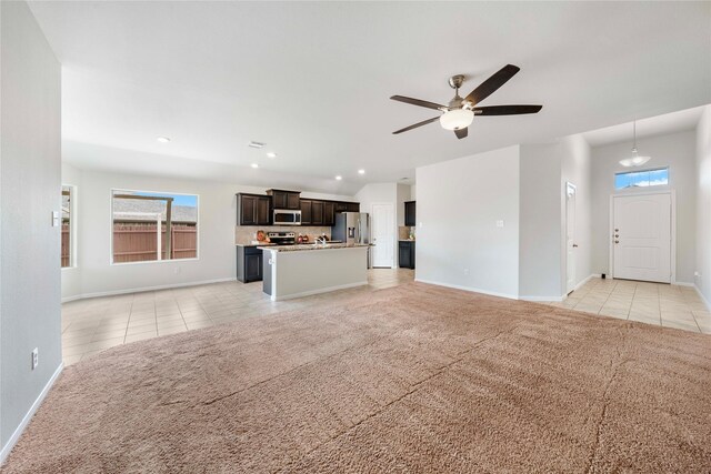 unfurnished living room featuring light colored carpet and ceiling fan