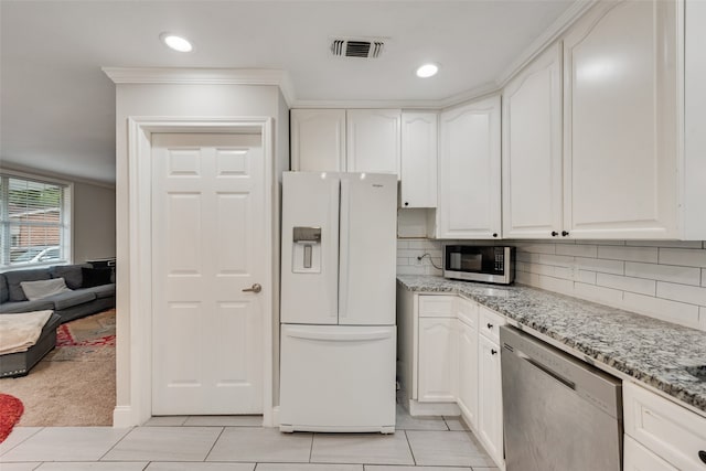 kitchen with light stone counters, white cabinets, appliances with stainless steel finishes, and light tile patterned floors