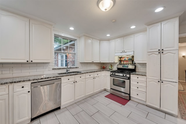 kitchen featuring sink, white cabinets, stone counters, and appliances with stainless steel finishes