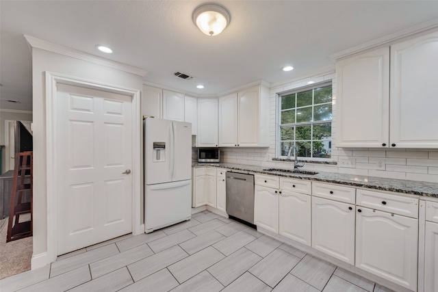 kitchen featuring white cabinets, appliances with stainless steel finishes, stone countertops, and sink