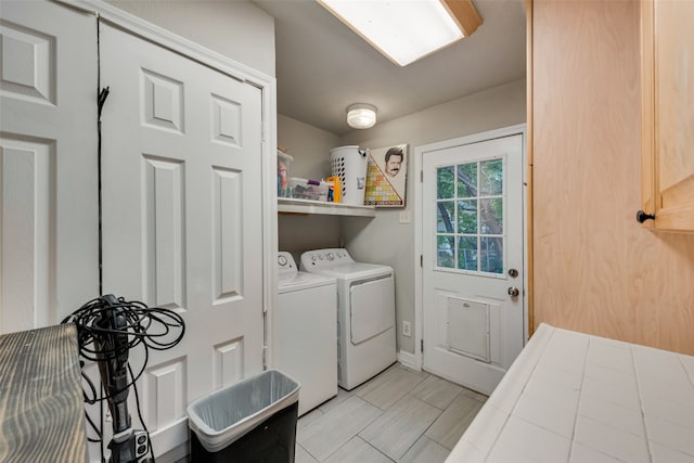 laundry room featuring washer and clothes dryer and light tile patterned floors