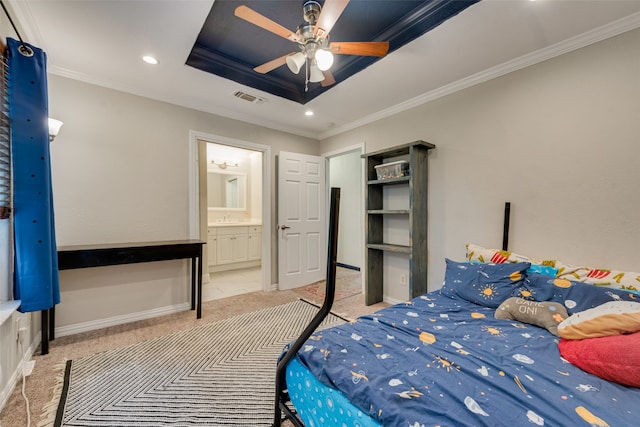 bedroom with a raised ceiling, ceiling fan, ensuite bath, and crown molding