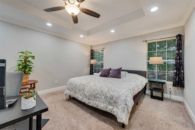 carpeted bedroom with ceiling fan, ornamental molding, and a tray ceiling