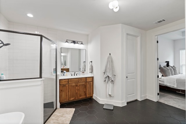 bathroom featuring tile patterned floors, tiled shower, and vanity