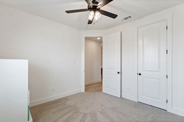 unfurnished bedroom featuring light carpet and ceiling fan