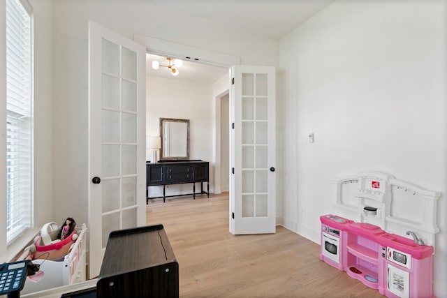 rec room featuring light wood-type flooring and french doors