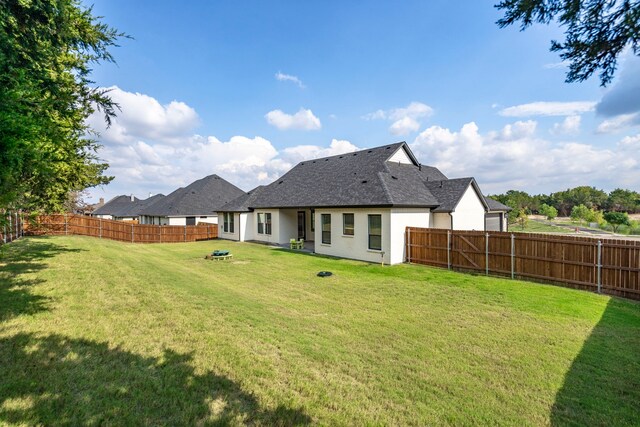 back of house with a lawn