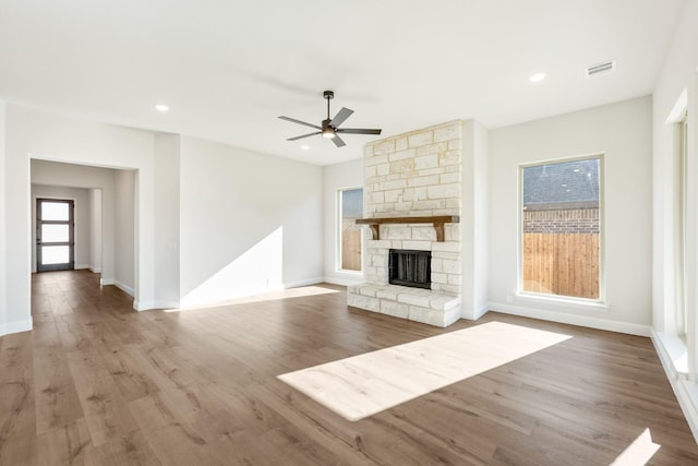 unfurnished living room featuring a fireplace, ceiling fan, and light hardwood / wood-style flooring