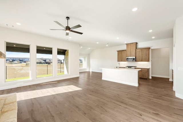 unfurnished living room with hardwood / wood-style floors, ceiling fan, lofted ceiling, and sink