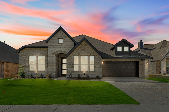 french country inspired facade with a lawn and a garage