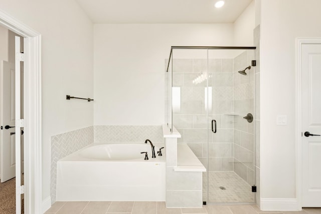 bathroom with tile patterned floors and independent shower and bath