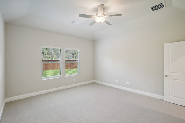 spare room with ceiling fan, vaulted ceiling, and carpet flooring