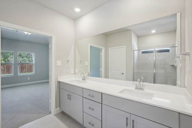 bathroom with a shower with door, tile patterned floors, and vanity