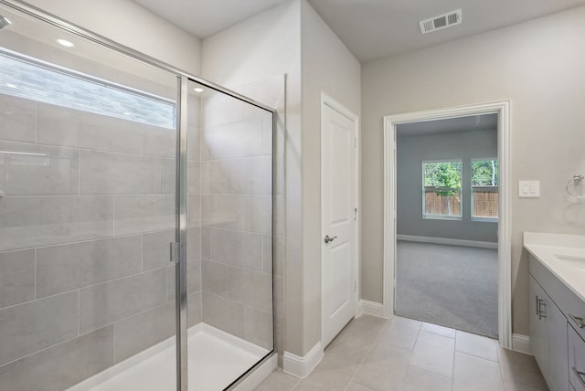 bathroom with tile patterned flooring, a shower with shower door, and vanity