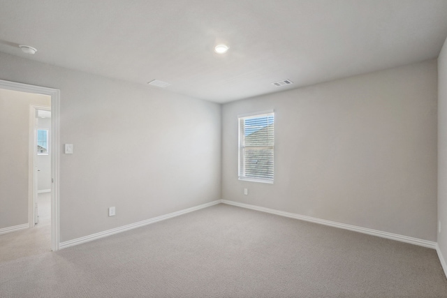 unfurnished room featuring light carpet