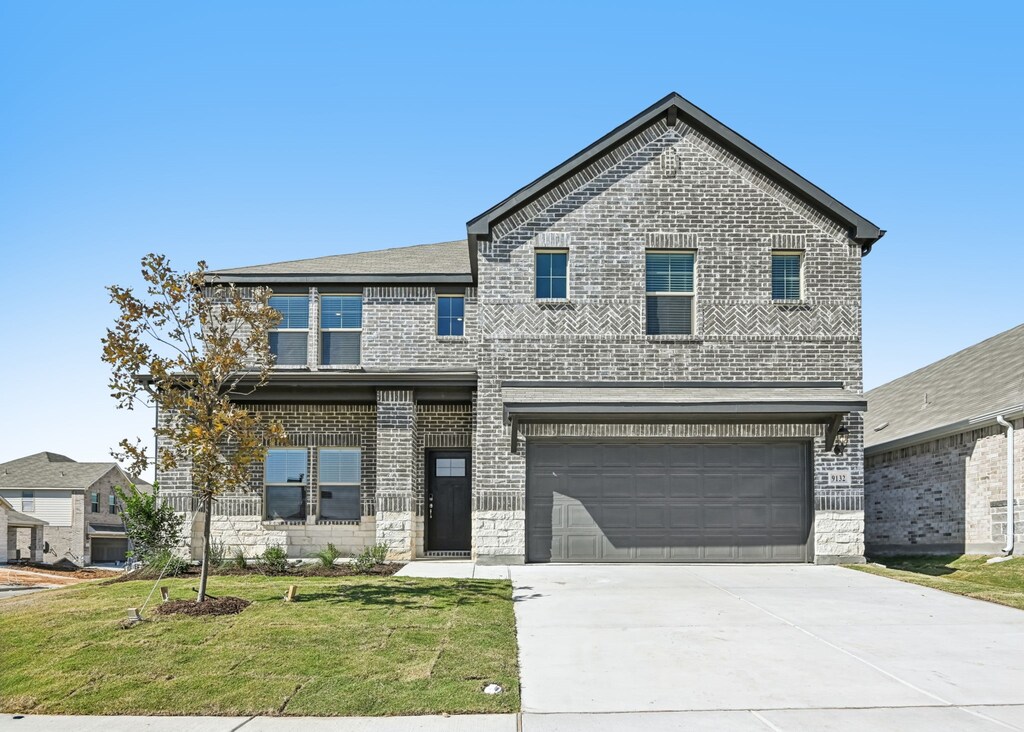 view of front of home with a front yard and a garage