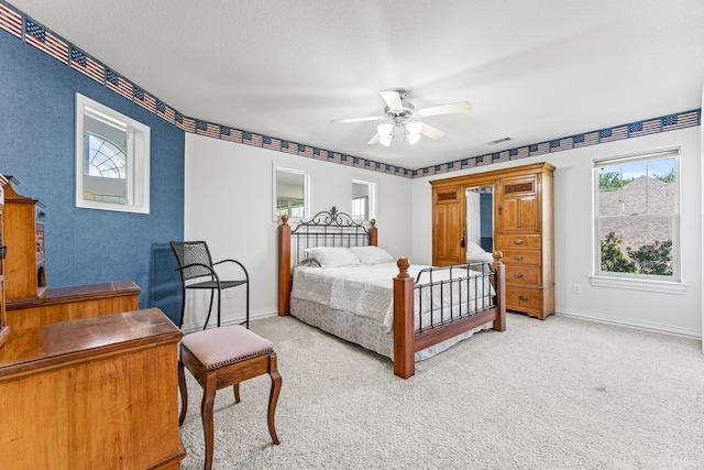 carpeted bedroom featuring a textured ceiling and ceiling fan