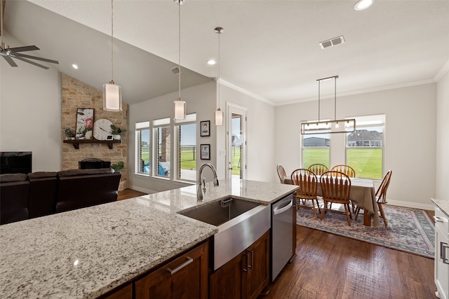 kitchen featuring a healthy amount of sunlight, ceiling fan, pendant lighting, and a stone fireplace