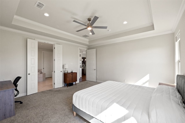 carpeted bedroom featuring ceiling fan, ornamental molding, and a tray ceiling