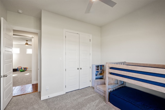 carpeted bedroom with ceiling fan and a closet