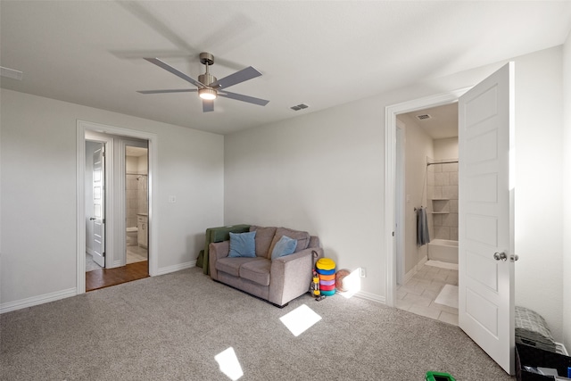 living area featuring ceiling fan and light colored carpet