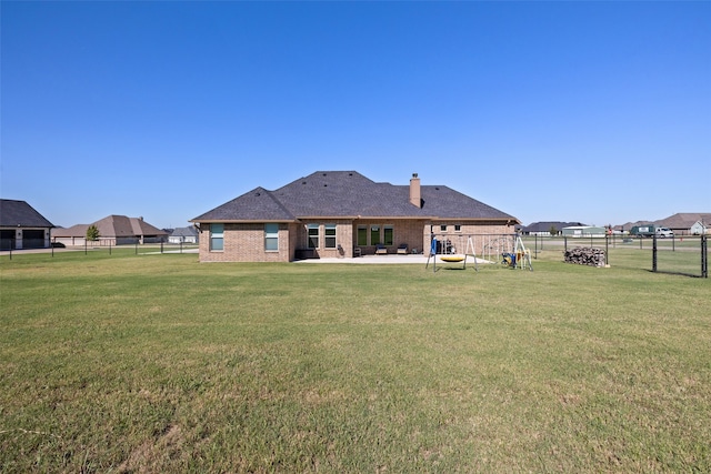 back of house with a lawn and a patio