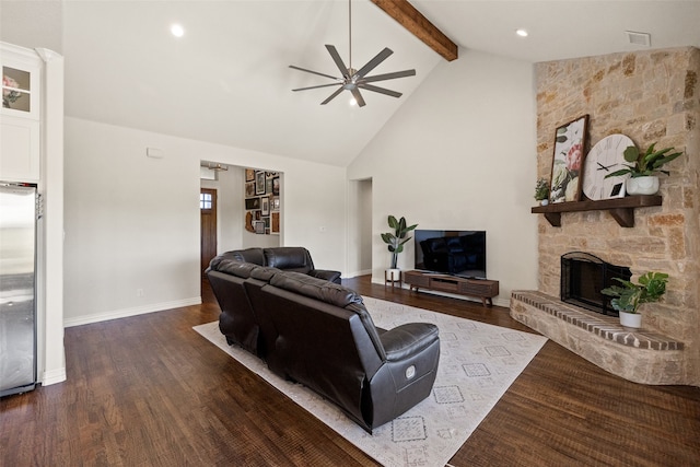 living room with beamed ceiling, ceiling fan, dark hardwood / wood-style floors, a stone fireplace, and high vaulted ceiling