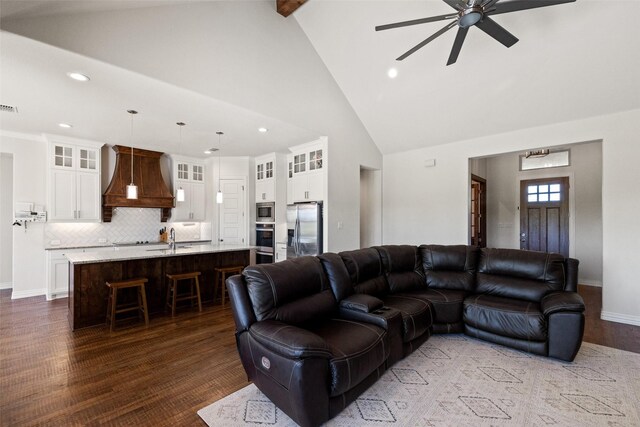 living room featuring dark hardwood / wood-style flooring, high vaulted ceiling, sink, and ceiling fan