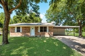 ranch-style house featuring a front lawn and a carport