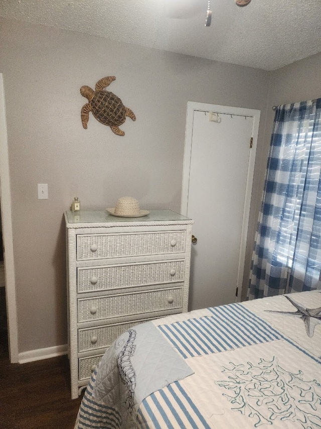 bedroom featuring a textured ceiling and dark hardwood / wood-style flooring