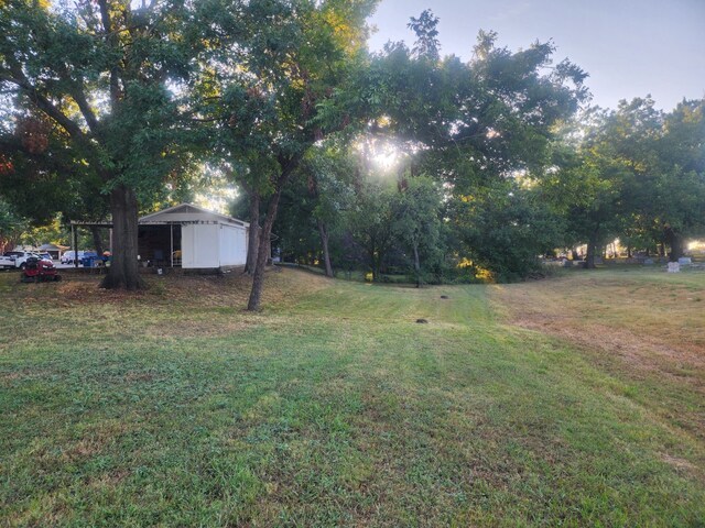 yard at dusk featuring an outbuilding