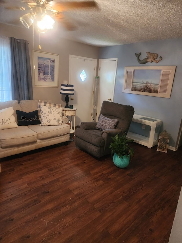 living room featuring a textured ceiling, dark wood-type flooring, and ceiling fan