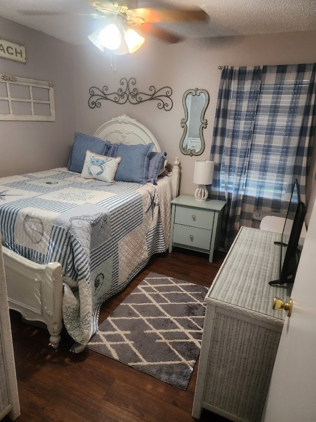 bedroom with ceiling fan, a textured ceiling, and dark wood-type flooring