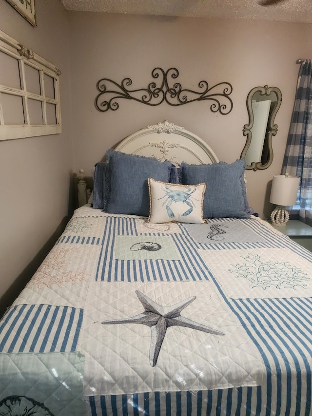 bedroom featuring ceiling fan and a textured ceiling