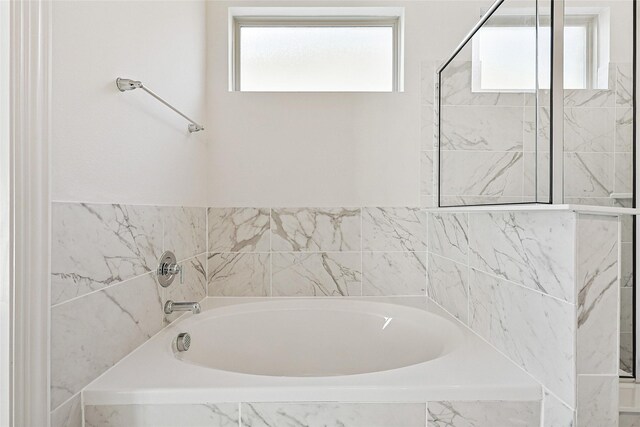 bathroom featuring a relaxing tiled tub