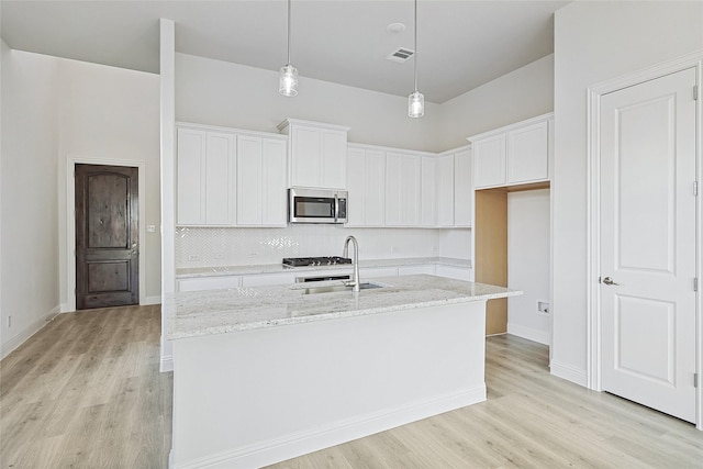 kitchen featuring sink, white cabinetry, and a kitchen island with sink