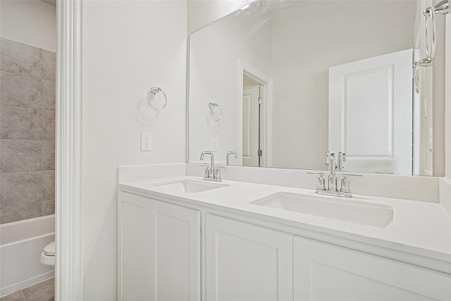 full bathroom with tile patterned flooring, vanity, tiled shower / bath, and toilet