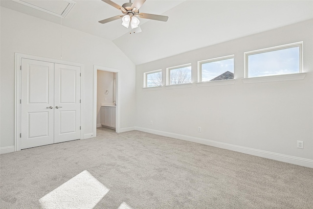 unfurnished bedroom with lofted ceiling, ensuite bathroom, light colored carpet, a closet, and ceiling fan