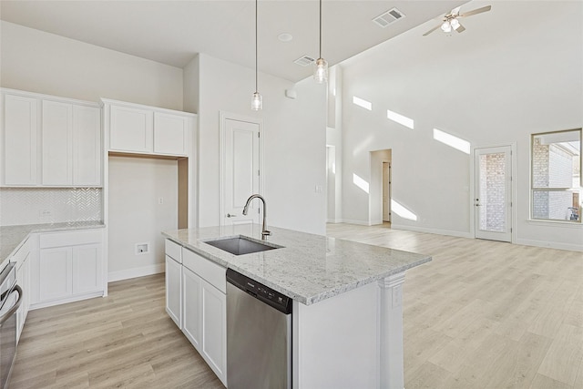 kitchen featuring white cabinetry, stainless steel dishwasher, and a center island with sink