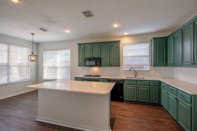 kitchen featuring black appliances, a center island, sink, and green cabinets