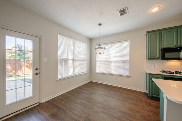 kitchen with dark wood-type flooring, hanging light fixtures, decorative backsplash, and green cabinets