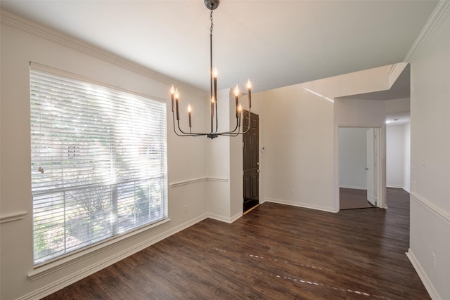 unfurnished dining area featuring dark hardwood / wood-style flooring, crown molding, and a notable chandelier