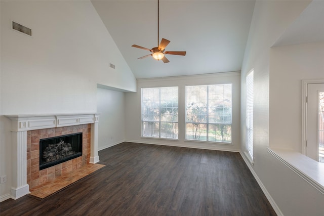 unfurnished living room featuring dark hardwood / wood-style flooring, a tile fireplace, high vaulted ceiling, and ceiling fan