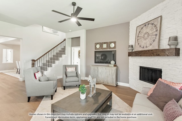 living room with light hardwood / wood-style flooring, ceiling fan, and a fireplace