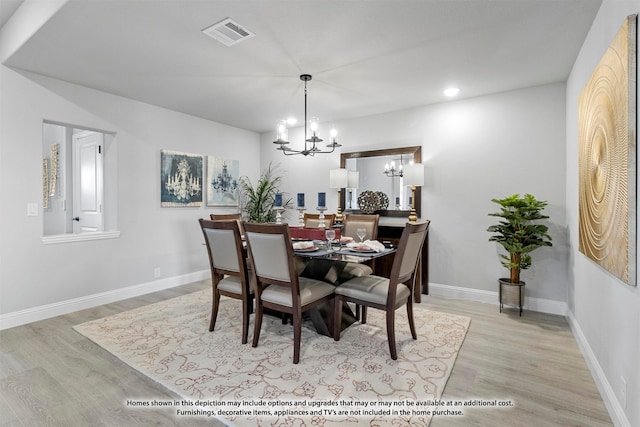 dining room featuring a notable chandelier and light hardwood / wood-style floors