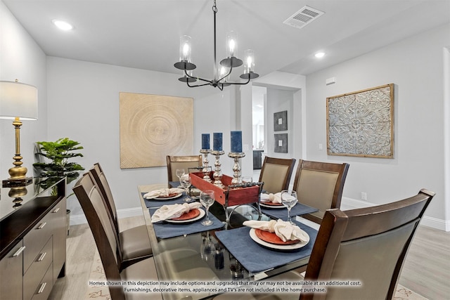 dining space featuring a notable chandelier and light wood-type flooring