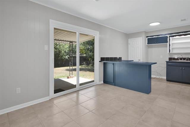 kitchen featuring tile patterned flooring, ornamental molding, and sink