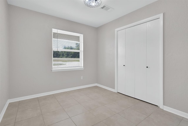 unfurnished bedroom featuring light tile patterned floors and a closet