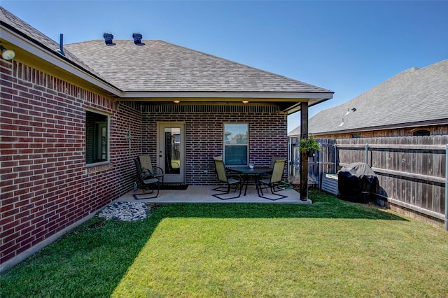 rear view of house with a yard and a patio